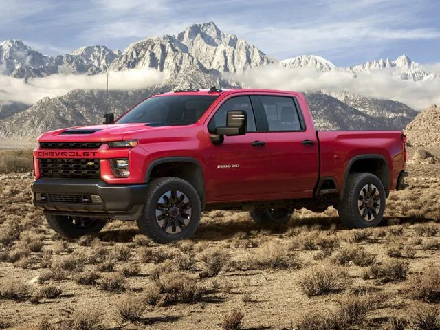 A red Chevy truck outside near a mountain