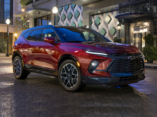 A red Chevy Blazer parked outside of a building at nighttime