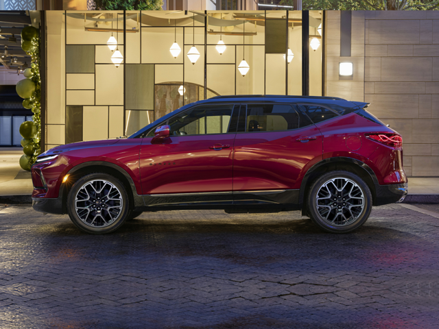A red Chevrolet Blazer parked next to a building