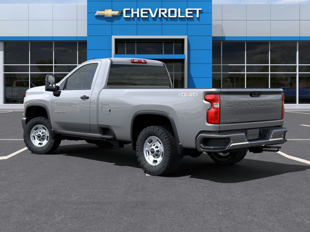 A silver truck parked outside a Chevrolet dealership